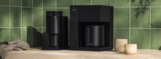 Fellow Aiden Precision Coffee Maker and Opus All-Purpose Grinder displayed on a table with cups
